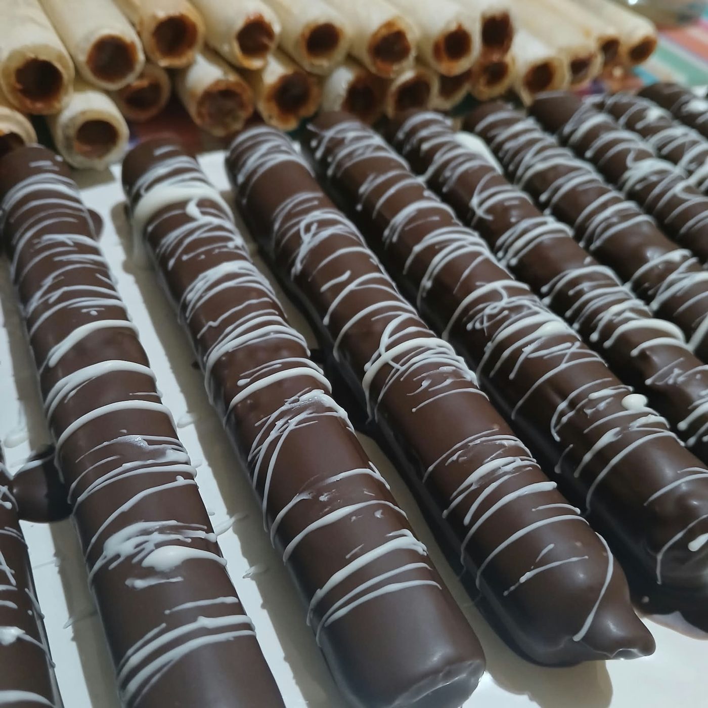 Cuchuflíes de D'amor bañados en chocolate con hilos de chocolate blanco.