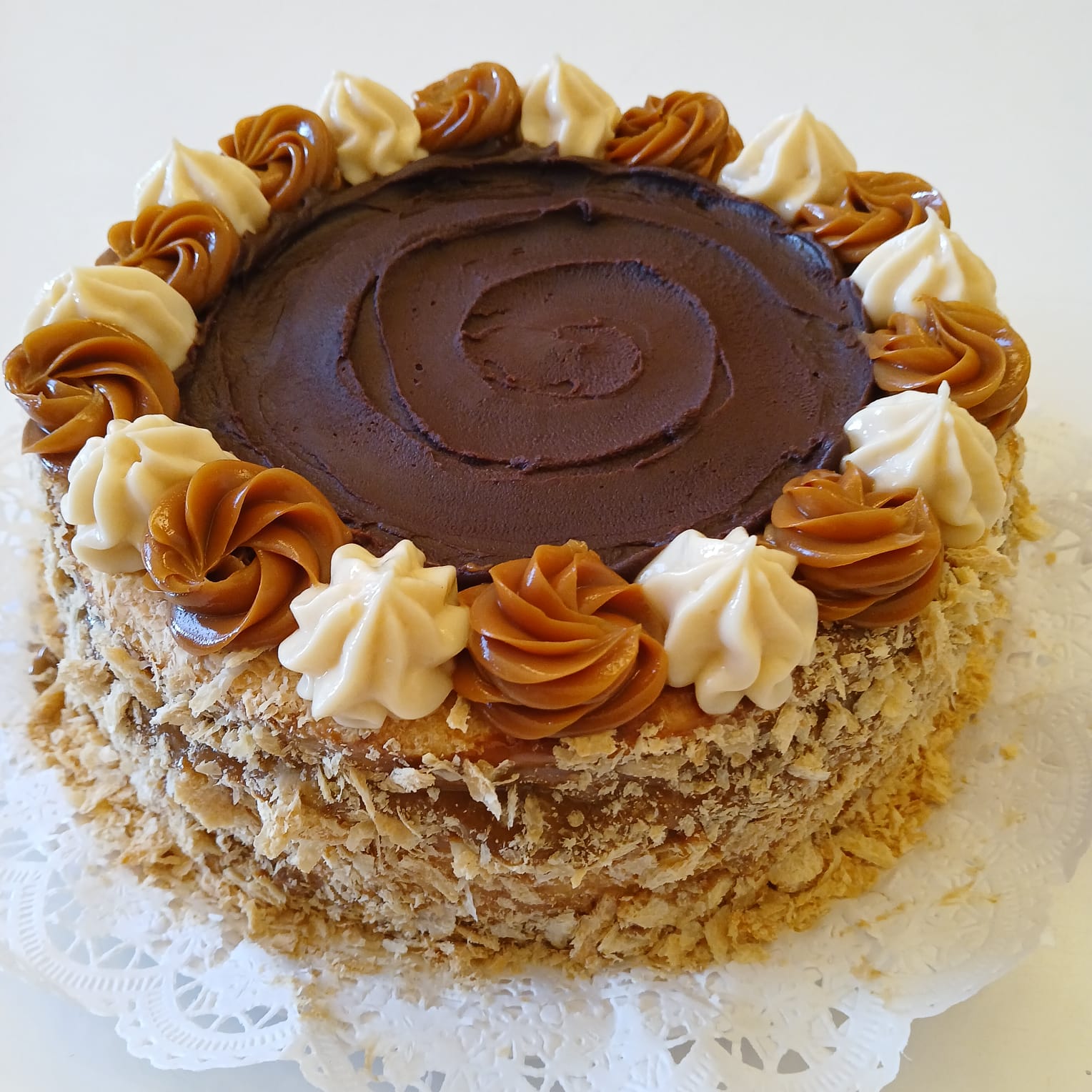 Torta de milhojas con manjar, crema chantilly y ganache de chocolate.